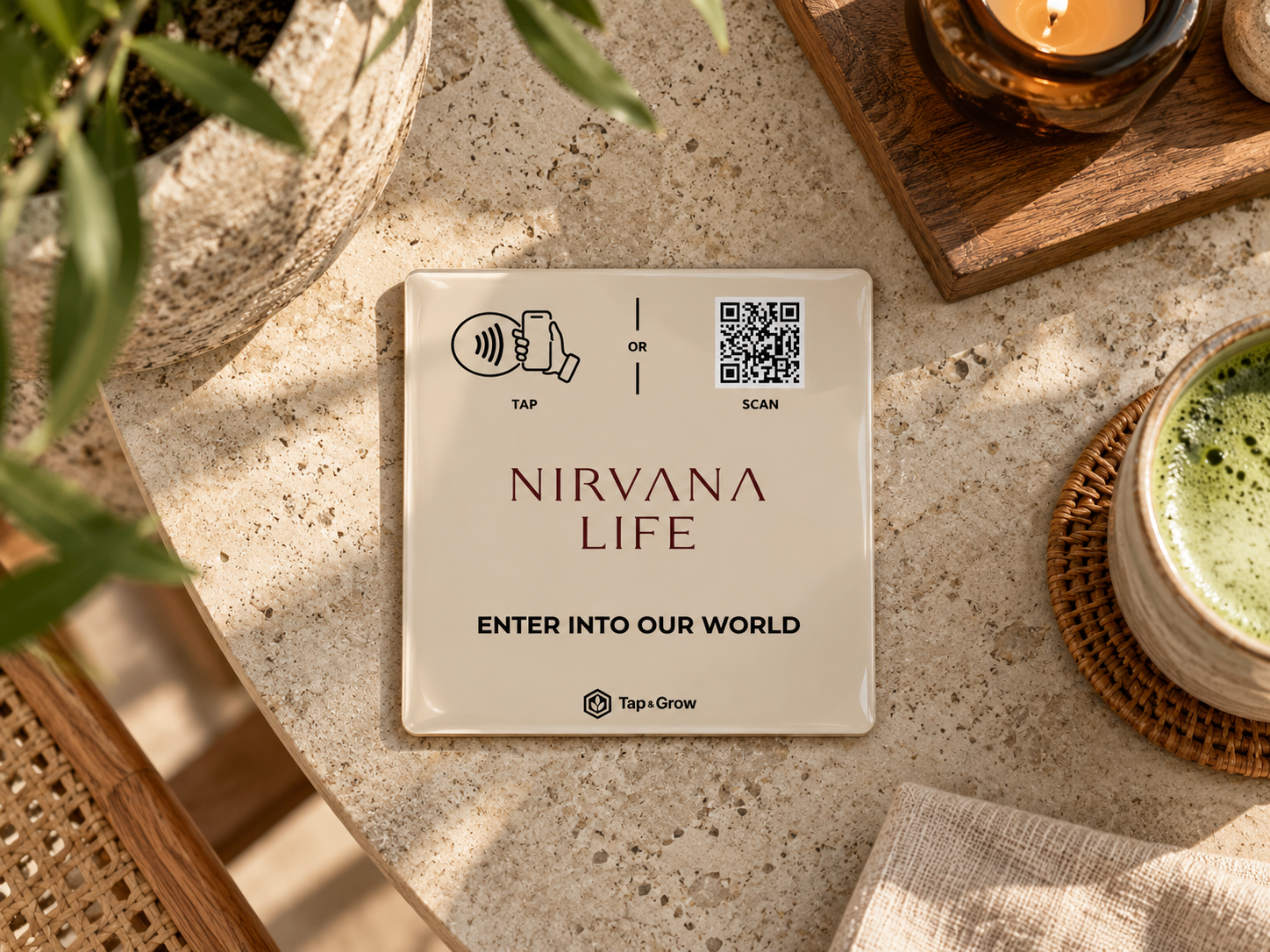 Concept NFC plaque for Nirvana Life on a sunlit table beside a green drink